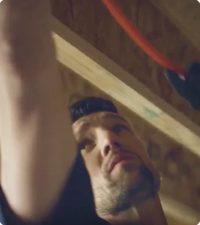 Contractor installing PEX tubing overhead
