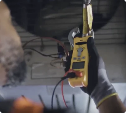 Technician testing HVAC equipment with a clamp meter