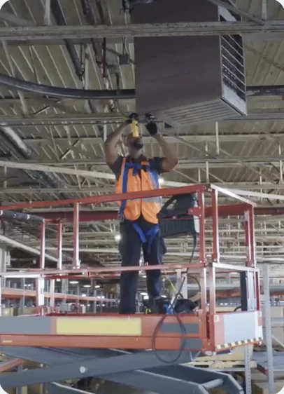 Technician installing a ceiling heater from a lift